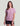 Woman wearing lavender short-sleeve t-shirt with chest pocket and circular logo, paired with black shorts.