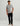 Gray short-sleeve t-shirt with circular pocket logo, worn with black pants.