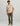 Beige short-sleeve t-shirt with chest pocket featuring circular HUK logo, styled with olive pants.