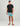 Man wearing black Huk tee with chest logo and turquoise patterned shorts.