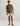 Olive green short-sleeve t-shirt with small chest graphic worn with patterned shorts.