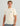 Cream-colored t-shirt with "Huk" script logo on chest, short sleeves, crew neckline.