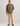 Man wearing olive green hoodie with small chest logo and tan pants.