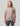 Beige t-shirt with small black graphic print on chest, worn with charcoal shorts.