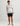 Man wearing light gray tie-dye hoodie with orange HUK logo and black shorts.