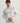 Men's light gray and white marble-patterned hoodie with orange HUK branding and sleeve text.