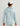Light blue patterned sun hoodie with hood, worn with white perforated cap, shown from back view.