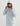 Light blue textured hoodie with attached hood and white visor, worn with white pants.