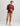 Burgundy hoodie with small front logo worn with patterned shorts and gray socks.