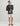 Man wearing charcoal long sleeve crew neck shirt with small logo on chest and white shorts.