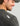 Man wearing charcoal long sleeve crew neck shirt with textured knit fabric and brand label visible on shoulder.