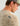 Beige textured long-sleeve crew neck shirt with woven pattern and brand label on back, worn by male model in profile.