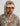 Tan and gray camo hoodie with fish print and "HUK" logo on chest, worn with matching cap.