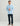 Man wearing light blue quarter-zip fleece with small embroidered logo and dark navy pants.