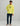 Man wearing a neon yellow hoodie with Huk logo, paired with dark navy pants and sandals.