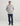 Man wearing light gray fleece hoodie with coral pocket linings, navy pants, and blue cap.