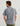Man wearing KC Kona button-down shirt with blue and red striped pattern, shown from back view.