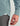 Sage green corduroy button-down shirt worn with gray pants, showing ribbed texture and sleeve detail on model.