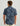 Men's short sleeve button-down shirt in blue with dark abstract camouflage pattern, back view.
