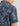 Man wearing blue and dark gray abstract patterned short-sleeve button-down shirt, back view.