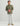 Olive green button-down shirt with chest pocket, worn with white pants and tan shoes.