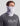 Gray and white camo gaiter worn around neck and lower face, with Huk logo visible on left side.