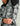 Man wearing gray and black tidal map print jacket with hood and front zip closure.