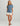 Blue short-sleeve pocket tee with crew neckline worn with cream shorts.