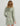 Sage green long-sleeve cover-up dress with cowl neckline and side drawstring details, shown from back view.