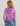 Woman wearing a purple hoodie with drawstring hood, shown from the back view.