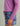 Purple hoodie with side tie detail and text on sleeve worn with patterned shorts.