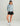 Women's hoodie with blue and white abstract pattern, quarter-zip closure, paired with black shorts and white slip-on shoes.