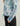 Women's hoodie with teal and white botanical print, drawstring hem, and "FISH" text on sleeve worn over black pants.