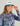 Woman wearing a multicolored abstract print pullover jacket with quarter-zip and long sleeves.