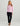 Woman wearing pink 1/4 zip long-sleeve top with black pants and brown sandals.