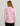 Woman wearing a pink long-sleeve quarter-zip pullover with black pants, shown from the back.