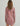Woman wearing a red and white geometric patterned long-sleeve cover-up dress with drawstring details at the hem.