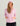 Woman wearing HUK Women's Coldfront+ Fleece Hoodie in Oleander Heather