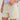 Beige shorts with button waistband and side pockets worn with lavender button-up shirt.