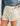 Cream-colored swim shorts with subtle leaf pattern, drawstring waist, and side pockets.