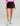 Huk women's Embark Skort in Black, UPF 50+ sun protection fishing bottoms, front view, alternate angle