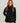 Black women's jacket with front zip closure and stand collar worn over purple undershirt.