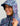 Women's hooded jacket with blue, purple, and teal storm print, drawstring closure, and navy cap visor.