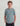 Boy wearing sage green short-sleeve t-shirt with small embroidered logo on chest and black shorts.