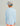Child wearing light blue long-sleeve crew shirt with white and blue baseball cap, shown from back view.