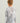 Child wearing gray and white camouflage crew neck long-sleeve shirt with orange text on back.