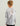 Child wearing gray and white camouflage crew neck long-sleeve shirt with orange text on back.