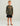 Child wearing brown mossy oak camo long-sleeve crew with orange HUK logo and black shorts.
