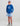 Child wearing blue Huk hoodie with white logo and sleeve text, paired with light blue patterned shorts.