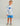 Child wearing white and blue speckled hoodie with blue fish logo and matching blue shorts.